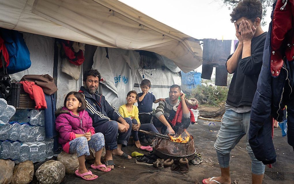 Alireza (rechts) hoopt het tot Duitsland te schoppen. Zijn vader en zusjes warmen zich aan het vuur. beeld Niek Stam