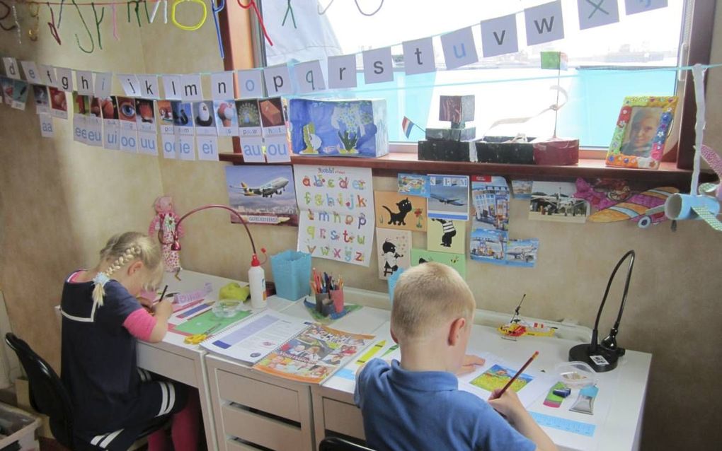 Magda en Jan Heuvelman in de schoolhoek aan boord van de Helena Geertje. Hun moeder geeft hun les aan de hand van materiaal van het Landelijk Onderwijs Varende Kinderen (LOVK). beeld fam. Heuvelman