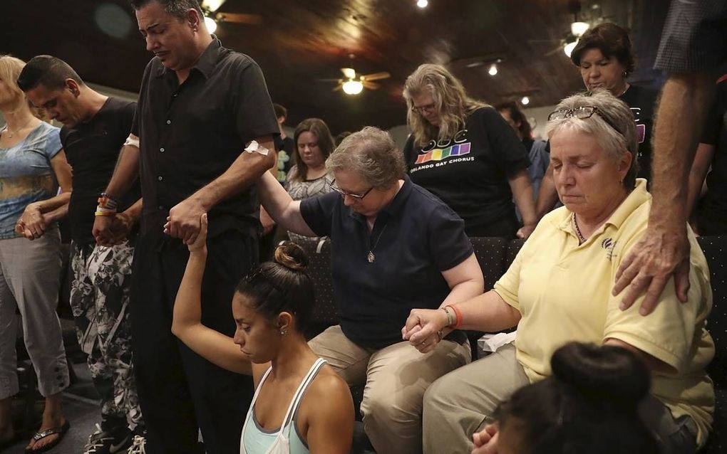 Gebedsbijeenkomst in de Joy MCC Church in Orlando, maandagavond. Tweede van links een overlevende van de aanslag in nachtclub Pulse, zaterdagnacht. In Amerikaanse kerken wordt massaal meegeleefd met de slachtoffers. beeld AFP, Joe Raedle