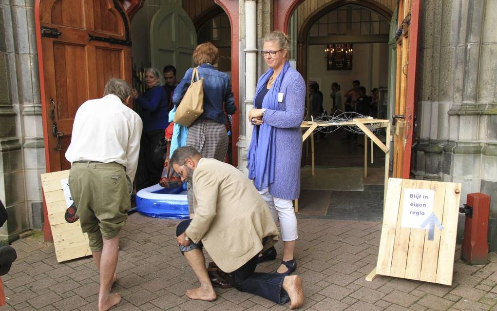 Om een beetje in de sfeer van de vluchtelingenproblematiek te komen, moesten bezoekers van de Joriskerk in Amersfoort zaterdag door het water waden of onder prikkeldraad door kruipen. beeld ZOA