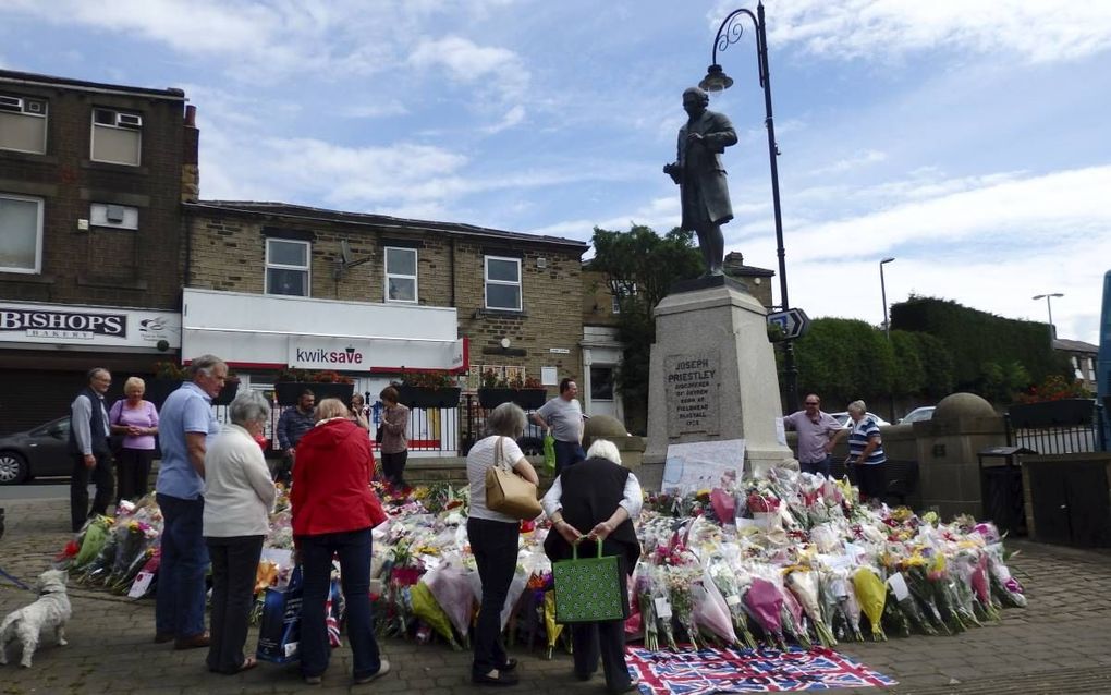 Op de kleine markt in Birstall ligt een veld van bloemen rond het standbeeld van Priestley. beeld RD, Evert van Vlastuin