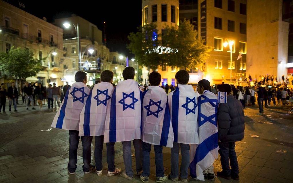 Israëlische jongens hullen zich in de vlag van Israël bij de viering van het 68-jarig bestaan van de staat Israël in mei. beeld EPA