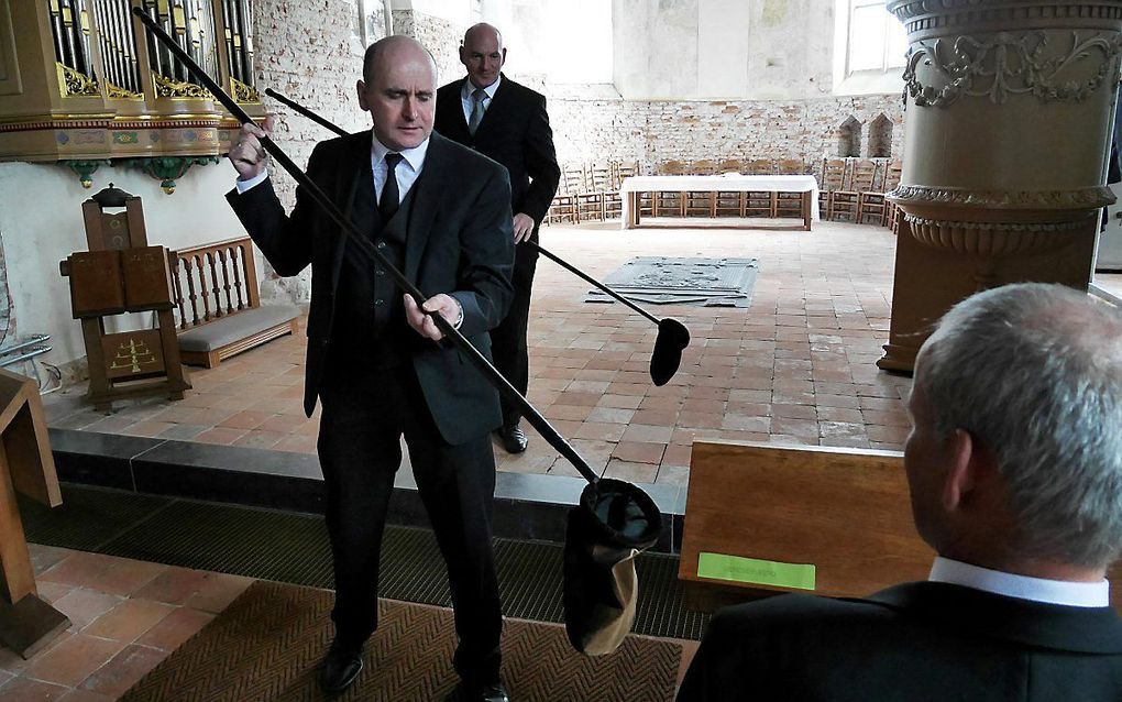 Collecteren op afstand tijdens een kerkdienst begin maart, in de hervormde gemeente Valburg-Homoet. beeld Vidiphoto