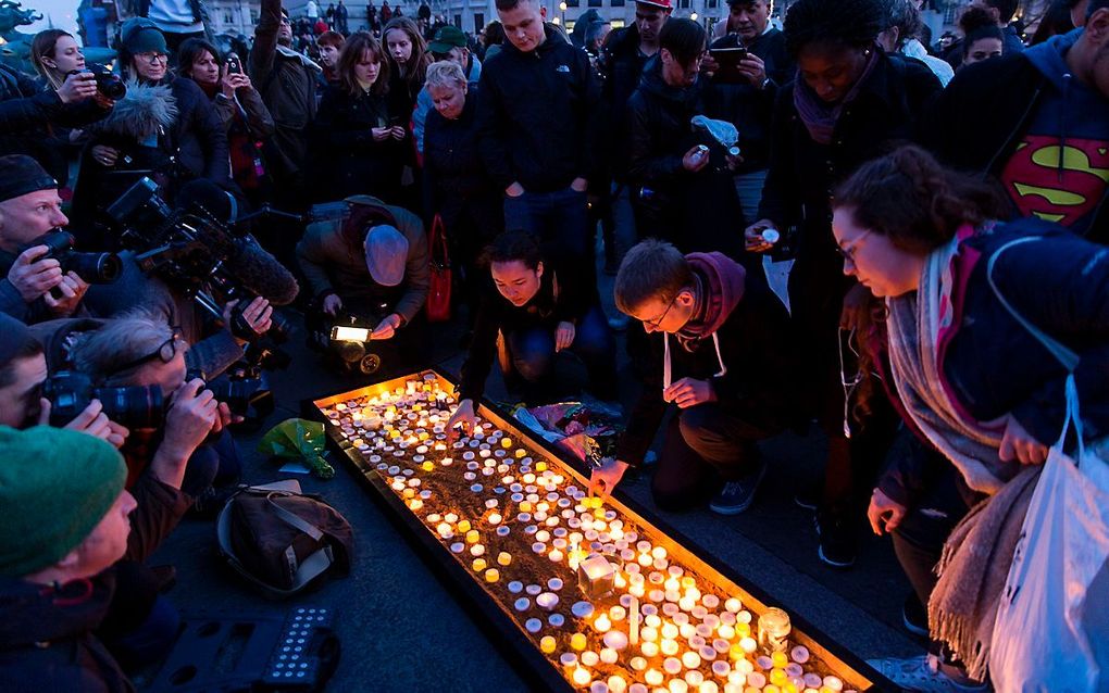 Mensen steken kaarsjes aan op Trafalgar Square in Londen. beeld AFP