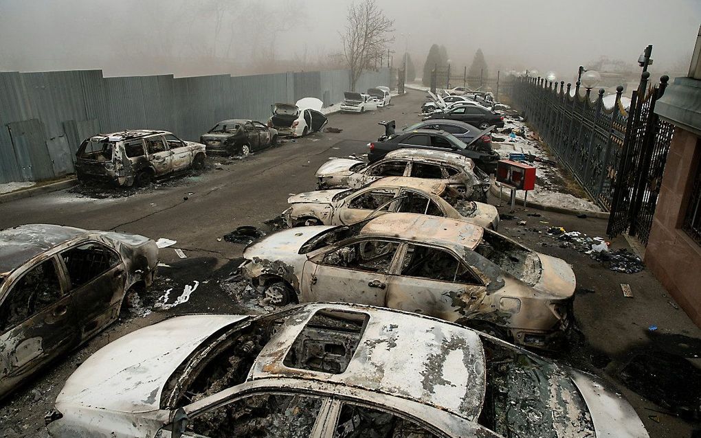 Uitgebrande auto's op een parkeerplaats in het centrum van Almaty. beeld AFP, Alexander BOGDANOV