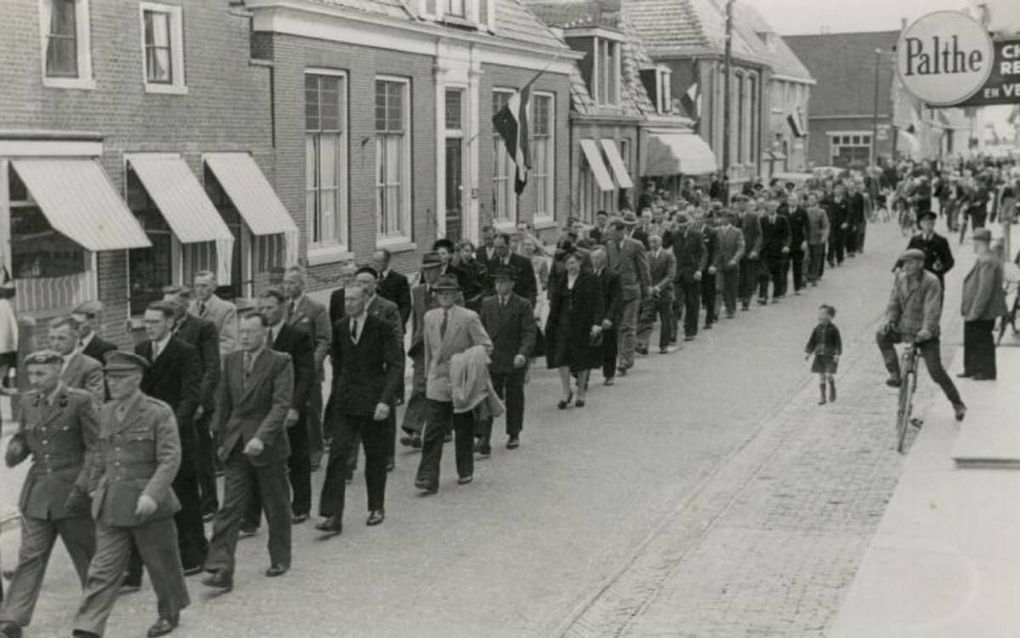 Begrafenisstoet in de Kerkstraat te Makkum, voorafgaand aan de herbegrafenis van zes verzetsmensen, onder wie Bob Dijkstra (BS). De rijmprent bij de foto sprak over „vrienden die op den 7de April 1945 door den vijand werden gemarteld en vermoord.” beeld V