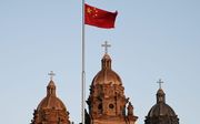 De Chinese nationale vlag voor de rooms-katholieke Sint-Jozefskerk in Peking. beeld AFP, Greg Baker