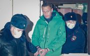 Navalni wordt uit een politiebureau buiten Moskou begeleid. beeld EPA, Sergei Ilnitsky
