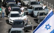 Automobilisten op een weg bij Jeruzalem stappen uit en houden een moment van stilte na het geloei van de sirenes. beeld EPA, Abir Sultan