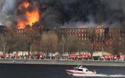 Brandweermannen blussen een brand in een historische fabriek in Sint-Petersburg.  beeld AFP
