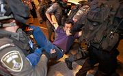 Een Palestijnse demonstrant wordt afgevoerd. beeld AFP, Menahem KAHANA