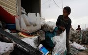 Een Jemenitisch kind werkt op een vuilnisbelt in Sana'a. beeld EPA, Yahya Arhab