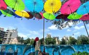 Een kunstwerk van gekleurde paraplu's in Mumbai, India. beeld AFP, Indranil MUKHERJEE