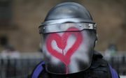 Een beschilderde helm van een agent tijdens een demonstratie van feministische groepen in in Mexico-Stad. beeld EPA, Sashenka Gutierrez