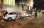 Een politieauto moet het ontgelden tijdens de rellen in Rotterdam op 19 november jongstleden. beeld ANP, VLN Nieuws