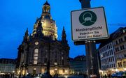 Mondkapje verplicht. Op de achtergrond de protestantse Frauenkirche in de Saksische hoofdstad Dresden. beeld AFP, Stringer