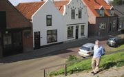 Schrijver Hans van Duivendijk bij Scheepswerf van Duivendijk B.V. in Bruinisse. Links het loodsje waarin onder meer zijn grootvader Pieter hoogaarzen bouwde. beeld uit ”Het liefst eigen baas"