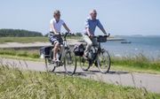 Hendrik Boot (48) en Willy Boot-Sinke (49) fietsen graag langs het water. „Als we terugkomen van vakantie, fietsen we op zaterdagmiddag vaak even naar de Oosterschelde. Als we die gezien hebben, zijn we echt weer terug in Zeeland.”  beeld Dirk-Jan Gjeltem