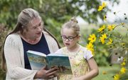 Gisette van Dalen-Heemskerk leest haar jongste dochter voor uit ”Bijbelse verhalen voor kinderen". beeld RD, Anton Dommerholt