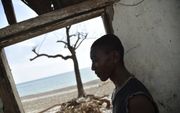 LES CAYES. Een inwoner van de Haïtiaanse stad Les Cayes in zijn verwoeste woning aan de kust. Zeker 1,4 miljoen Haïtianen hebben volgens de Verenigde Naties dringend hulp nodig na de orkaan Matthew. beeld AFP, Hector Retamal