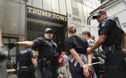 De politie in New York moet regelmatig tegenstanders van Trump die de Trump Tower blokkeren, verwijderen.  beeld AFP, Spencer Platt