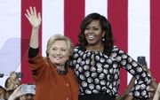 WINSTON-SALEM. Hillary Clinton en First Lady Michelle Obama op campagne. Het schandaal rond het e-mailverkeer van Clinton blijft haar achtervolgen na nieuwe ontwikkelingen van WikiLeaks. beeld AFP, Alex Wong