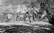 Nederlandse mariniers trekken op 22 juni 1946 in de omgeving van Soerabaja door een brandende kampong. De foto is gemaakt door legerfotograaf Hugo Wilmar. beeld Nederlands Instituut Militaire Historie
