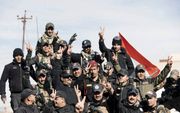 Iraakse elitetroepen vierden gisteren dat het oosten van de stad Mosul weer geheel in handen is van regeringstroepen. beeld AFP, Dimitar Dilkoff