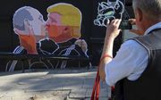 Op de Berlijnse Muur stonden ooit cartoons waarop De Oost-Duitse leider een kus gaf aan de sovjetleiders Brezjnev en Gorbatsjov, gebaseerd op werkelijke foto’s. In de Litouwse hoofdstad Vilnius heeft men alvast een voorschot genomen op de omhelzing van Po
