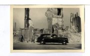 Een auto passeert ruïnes als gevolg van het bombardement op 14 mei 1940 op een onbekende weg in Rotterdam. beeld Museum Rotterdam 40-45 NU