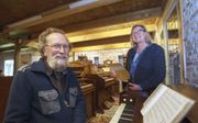 Henk en Marijke Braad staan bij het bijzondere tafelharmonium dat organist Jan Jongepier hun schonk. Het is een van de zestig harmoniums van hun Harmonium Museum dat ze naast een galerie bij huis hebben.  beeld Rens Hooyenga