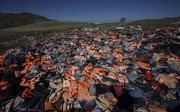 Honderden zwemvesten liggen op een grote berg op Lesbos. Vluchtelingen gebruikten de vesten op hun tocht naar het Griekse eiland. beeld ANP, Arie Kievit