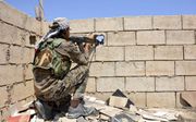 RAQQA. Een strijder van de Koerdische SDK vuurt op IS-troepen in Raqqa, de zelfuitgeroepen hoofdstad van het kalifaat. beeld EPA, Youssef Rabie