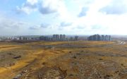 Luchtopname van de locatie waar de opgravingen worden verricht. Op de achtergrond de stad Rosh Ha-Ayin. beeld Yitzhak Marmelstein, Israelische Oudheidkundige Dienst