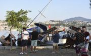 Tussen de Turkse kust en het Griekse eiland Kos heeft vannacht een aardbeving plaatsgevonden. Op Kos kwamen twee mensen daardoor om het leven. Foto: beschadigde boten in de haven van Mugla, in de Turkse provincie Bodrum, vanmorgen. beeld AFP, Ali Balli