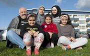Vader Jarah met zijn gezin voor hun appartement even buiten het centrum van Reykjavik. Moeder Fotoun Nahlawi (37) en haar oudste dochters Wafika (17) dragen een hoofddoek. Dat geld nog niet voor de drie dochters Masa (13), Bailesam (7) en Ritaj (5). beeld