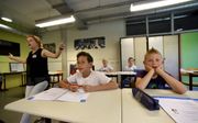De jongensklas van Zomerschool058 in Leeuwarden zingt de tafelrap. Volgens juf Hanneke Smit (l.) leren jongens sneller wanneer er veel afwisseling in de les is door tussendoor te zingen en te bewegen. beeld Marchje Andringa
