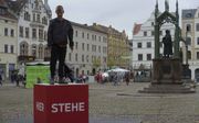 Het grote plein in Wittenberg, met op de achtergrond een standbeeld van Luther. Op een verhoging staan de woorden van de reformator: ”Hier stehe ich.” „De Reformatie vraagt ook aan ons: waar sta ik voor?”  beeld Ruben Stoel