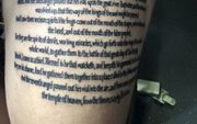 Een tattoo met een stuk tekst uit Bijbelboek Openbaringen. beeld BBA Tattoo