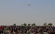 THONYOR. Zuid-Sudanezen wachten op een helikopter met voedsel, op 27 februari. In Zuid-Sudan werd in februari offi­cieel een hongersnood uitgeroepen. Die zou vijf maanden aanhouden. beeld AFP, George Fominyen