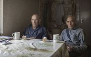 De broers Jaap en Nees Terlouw uit Goudriaan eten op hun verjaardag een halve tompouce. beeld Ferry Verheij