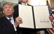 De Amerikaanse president Donald Trump toont de handtekening onder het besluit waarmee de Verenigde Staten Jeruzalem formeel erkennen als hoofdstad van Israël. beeld EPA, Jim Lo Scalzo