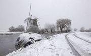 Een auto raakte zaterdag in Abcoude deels te water. De winterse buien bedekten delen van Nederland zaterdag, zondag en maandag onder een witte deken en zorgden voor gladheid op de wegen. beeld ANP, Peter Bakker