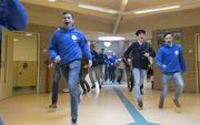 Pabostudenten rennen De Wittenbergschool in Scherpenzeel binnen om voor één middag het lesprogramma over te nemen. De mannen willen meer meesters voor de klas. beeld Herman Stöver