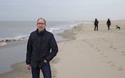 A Rocha-medewerker Bert van der Woerd uit Delft op het strand bij Monster . Van der Woerd leidt het onderzoek naar de herkomst van kunstofkorrels in het zand langs onze kust. beeld Anton Dommerholt
