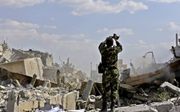 Een Syrische soldaat inspecteert de ruïne van een wetenschappelijk instituut in noord-Damascus. Dit gebeurde zaterdag tijdens een door de Syrische regering georganiseerde persreis over de gevolgen van de geallieerde aanval op Syrische doelen in de nacht v