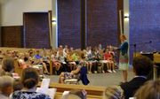 HHJO-jeugdwerkadviseur Marleen Vos-van Aalst leert een Bijbeltekst aan met gebaren erbij. beeld RD