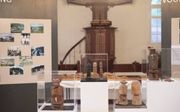 De Papoea-beeldjes midden in de kerk, gezien vanaf de entree. Daarachter bevindt zich. symbolisch de kansel met opengeslagen Bijbel. beeld Sjaak Verboom