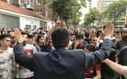 Moslims drommen samen voor de Laleli-moskee in Rotterdam. Voorzitter Türan Atmaca van de Turkse organisatie UETD roept op tot kalmte tijdens een demonstratie van Pegida.  beeld Gerard ten Voorde