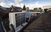 Pieter Loosman uit Urk bij zijn lucht-water warmtepomp. Sinds twee jaar gebruikt hij helemaal geen gas meer. beeld RD, Freddy Schinkel